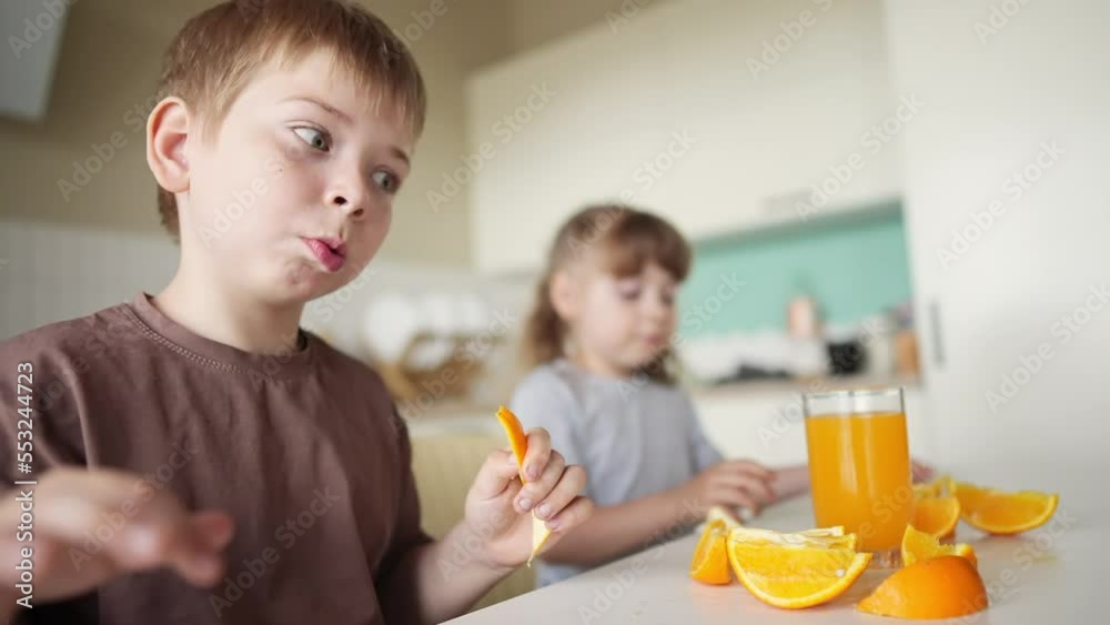 children eat oranges. happy family a kid dream concept. drinking fresh juices. morning breakfast brother and sister eat oranges in the kitchen lifestyle. fruits orange juice healthy eating children eat oranges. happy family a kid dream concept. drinking fresh juices. morning breakfast brother and sister eat oranges in the kitchen lifestyle. fruits orange juice healthy eating