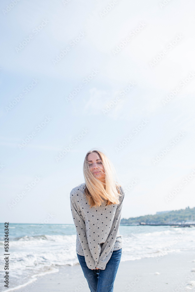 Portrait of a happy smiling woman walking outdoors on the seashore in the sunshine Portrait of a happy smiling woman walking outdoors on the seashore in the sunshine