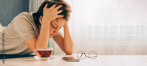Canvas Print Depressed adult woman covers her face with her hands, cries, feels despair, grie