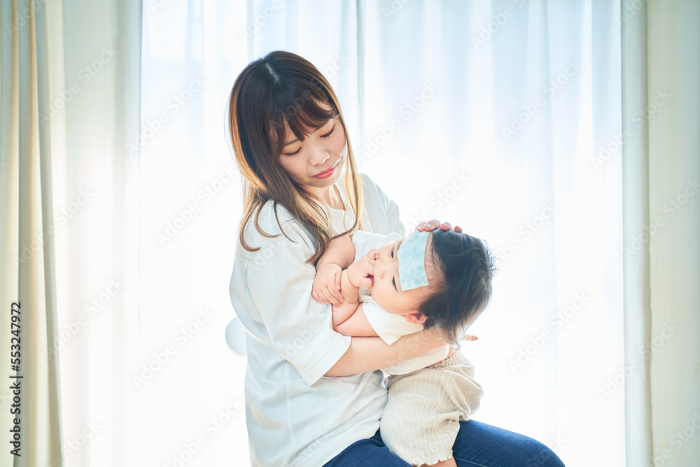 発熱した幼児とお世話するお母さん 発熱した幼児とお世話するお母さん