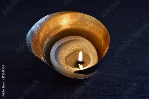 burning candle in a golden candlestick