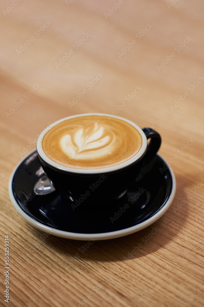 Cup of coffee on the table in cafe. Cappuccino or latte in mug. Enjoying time alone Cup of coffee on the table in cafe. Cappuccino or latte in mug. Enjoying time alone