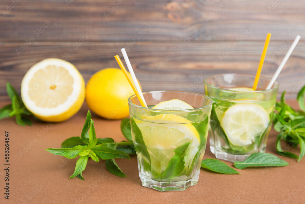 Fototapeta premium Mojito summer refreshing cocktail with ice and mint. mojito cocktail with lime, lemon and mint in a tall glass with a stick