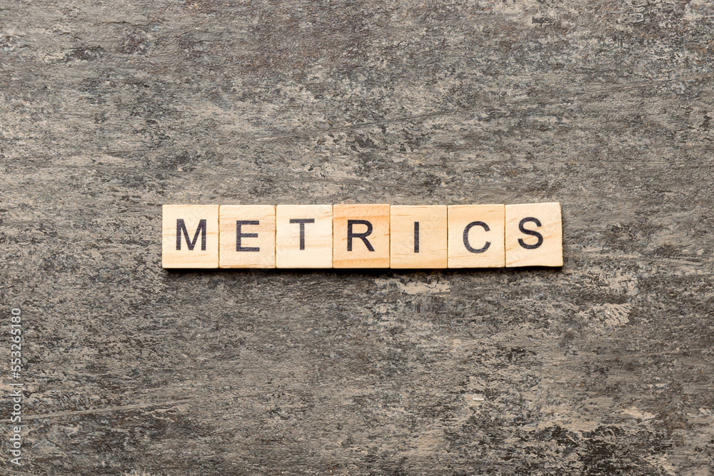 Fototapeta premium METRICS word written on wood block. METRICS text on cement table for your desing, concept