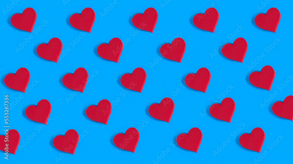 Red hearts on the blue background. Pattern. Flat lay. Holiday background.