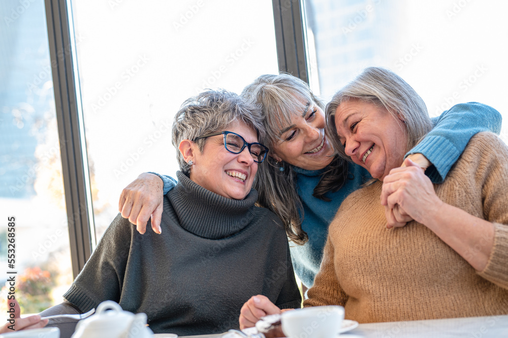 Three mature senior women friends having fun together, elder lifestyle of woman having breakfast on morning, aging and friendship concept