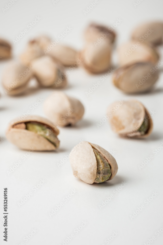 Close up of pistachio nut seeds in shells isolated on the white background. Salted dried beer snack. Macro shot