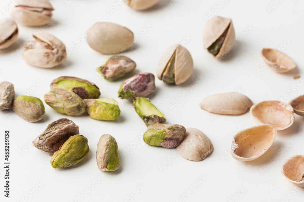 Close up of peeled pistachio nut seeds isolated on the white background. Salted dried beer snack. Macro shot