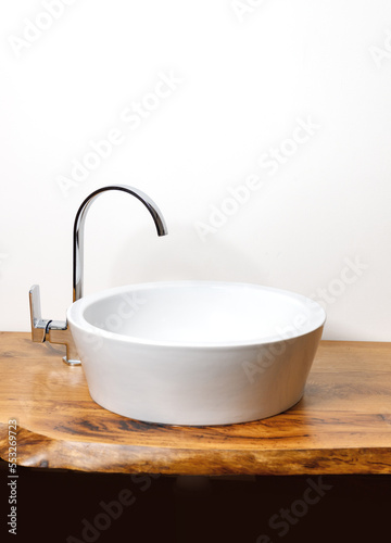 White ceramic sink with faucet on wooden contemporary countertop