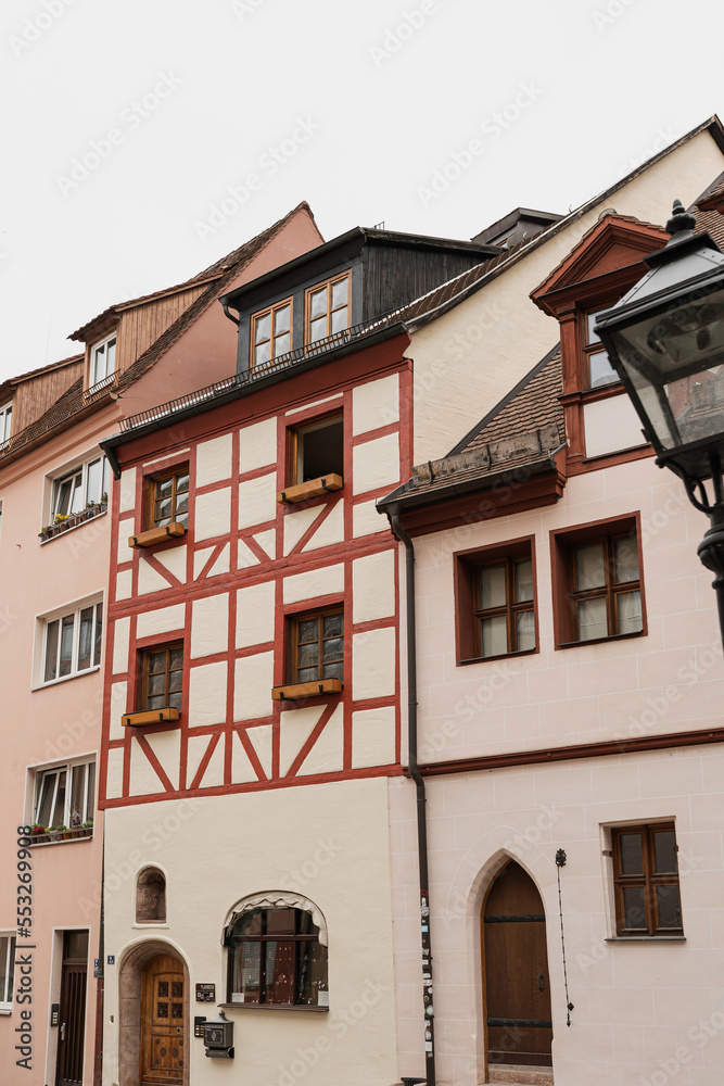 Old historic architecture in Nuremberg, Germany. Traditional European old town buildings with wooden windows, shutters and colourful pastel walls. Aesthetic summer vacation, tourism background