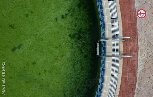 Drone point of view of a Deserted swimming pool. Poll lader green dirty water photo