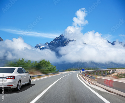 Picturesque road in the mountains and a white car.