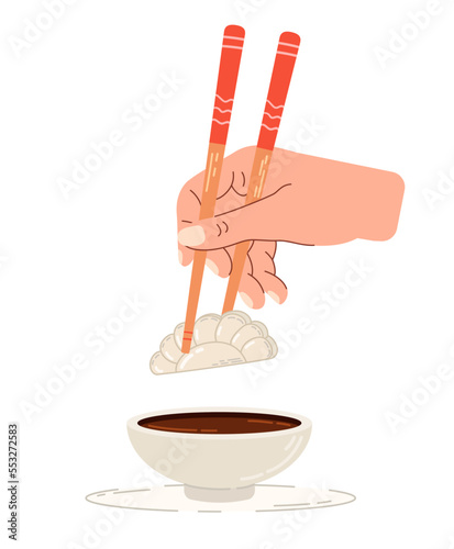 Dip gyoza in soy sauce. Chinese chopsticks in hand.