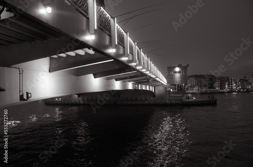 Cold dark Bosphorus sea under Galata bridge with evening city lights on a winter night. Cinematographic long exposure