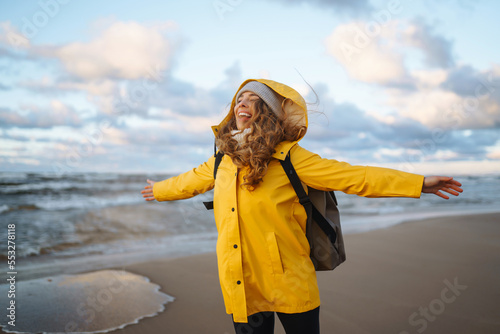 Photos Happy tourist in a yellow jacket  enjoying sea landscape