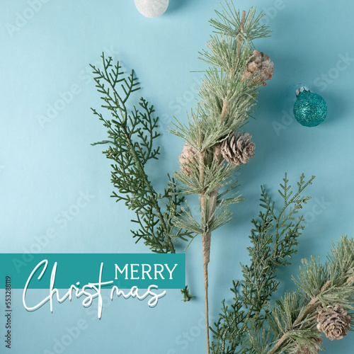 Blue holiday flat lay greeting with Merry Christmas text and decorations in minimal style.