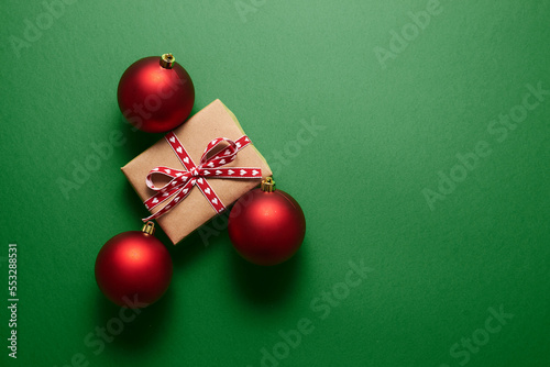Christmas decoration and gift box on green background.