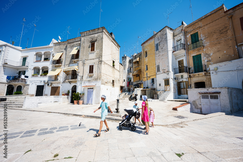 Family of tourists waking in streets Bari, Puglia, South Italy.