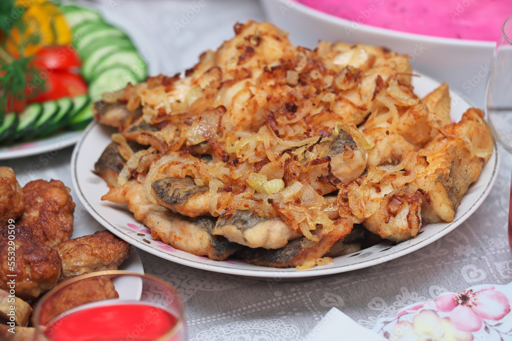 Festive table with food for New Year or Christmas. Fried fish with onions, Shuba salad, chopped vegetables, fried cutlets, compote. Festive table with food for New Year or Christmas. Fried fish with onions, Shuba salad, chopped vegetables, fried cutlets, compote.