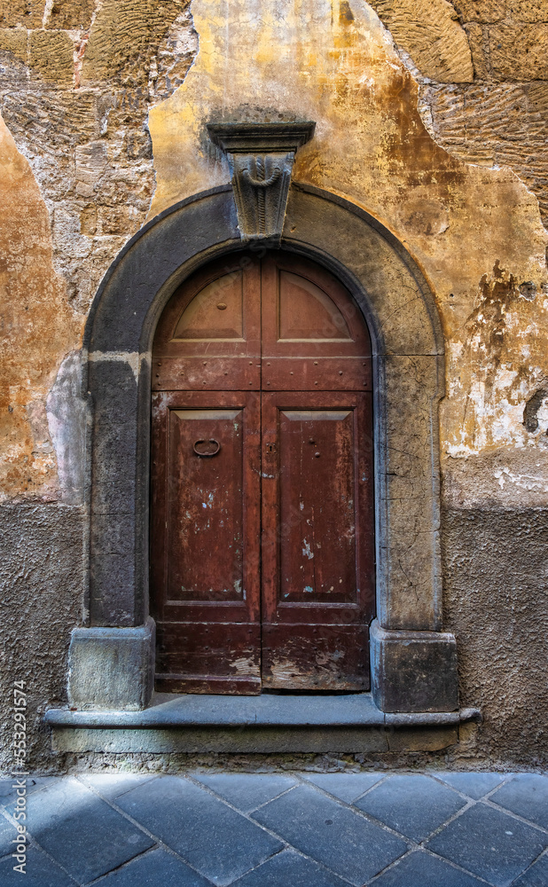 A very old medieval door with a rough wall