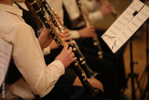 Foto A group of children playing wind instruments at a school concert sitting in a ro