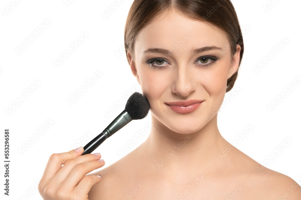 Woman using make-up brush, isolated on white background