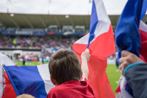 Un enfant dans les tribunes du stade, brandit le drapeau français bleu blanc rouge
