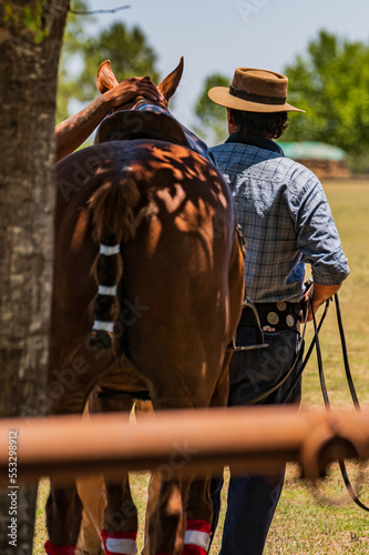 Un gaucho argentino junto a su caballo en el palenque