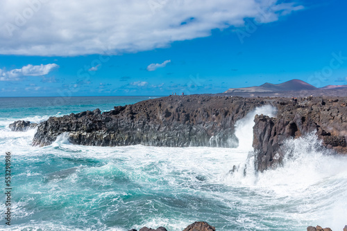 Powerful waves of the Atlantic Ocean crashing on the volcanic cliffs of Los Hervideros in Lanzarote, Canary Islands, Spain