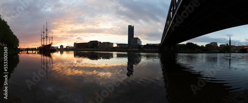 sunset at the river Weser in Bremen with reflection of the office buildings of the Überseestadt