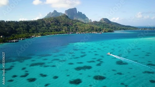 4K Aerial Drone footage of a cruising boat and Mount Otemanu in Bora Bora, Tahiti, French Polynesia. Turquoise blue lagoon in Bora Bora. Luxury, romantic vacation, honeymoon exotic destination.