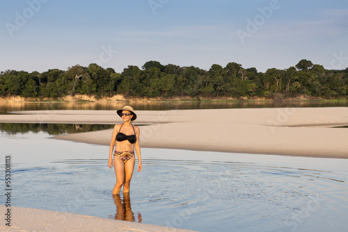  Lady Standing on a sand bar in the middle of the Rio Negro late in the day near Novo Airao, Brazil photo