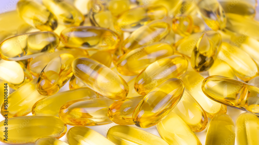 Fototapeta premium Omega 3 fish oil supplement softgel capsules background. Health care, cardiovascular support, medicine, pharmacy concept. Top view, flat lay, banner, header