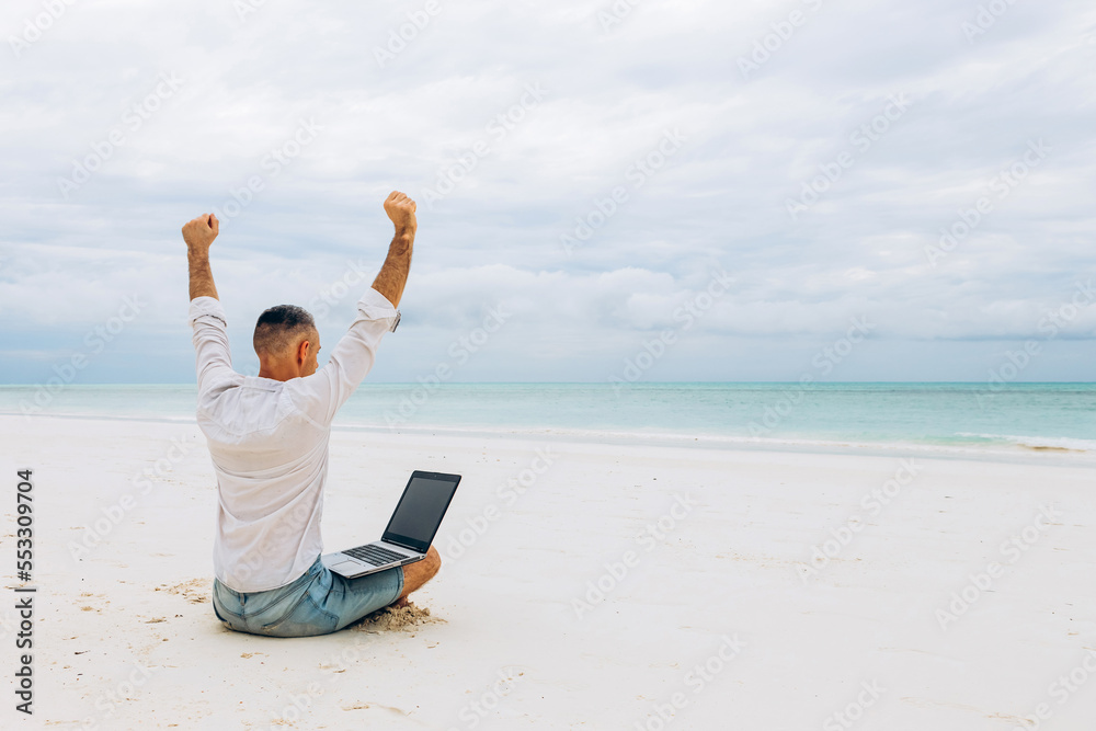 Successful Young man using laptop computer on the beach. Relaxation Vacation Working Outdoors Beach Concept