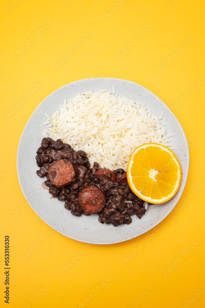 Typical brazilian food beans with sausages and rice Feijoada on white dish Typical brazilian food beans with sausages and rice Feijoada on white dish