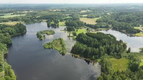 Swedish archipelago in aerial drone shot flying over forest and islands. Silhouette islands in the archipelago, Aerial view from the Swedish archipelago. . Trees and green woods on warm summer evening photo