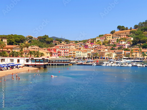 City of Porto Azzuro with colorful houses and tourists on the beach. photo