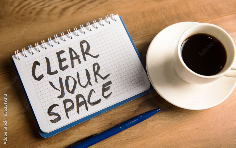 The inscription on the notebook Clear your space and a cup of coffee The inscription on the notebook Clear your space and a cup of coffee