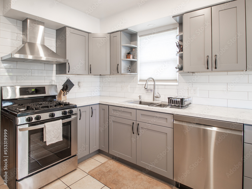 A beautiful small modern kitchen with grey cabinets in Luxury Home with Stainless Steel stock photo A beautiful small modern kitchen with grey cabinets in Luxury Home with Stainless Steel stock photo