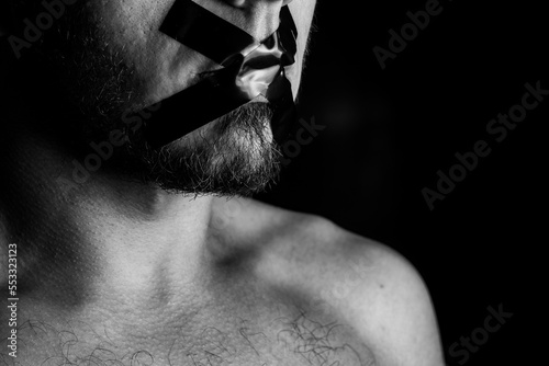 A man who can't speak because his mouth is covered with tape photo