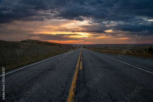 Driving down the road into the cloudy sunset