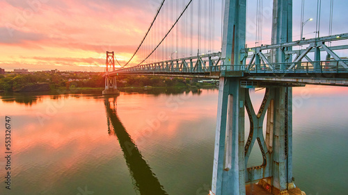 Canvas Print Pink and golden sunrise light behind stunning American bridge on Hudson River