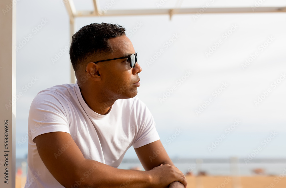 Fototapeta premium Handsome Latino man enjoying day at beach at hotel