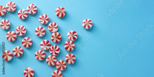 Close-up striped caramel candies on blue background. Christmas banner for candy shop. Selective focus  copy space.