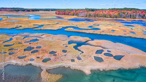 Fotografi Aerial over stunning marshes of Maine with fall forests and patches of water