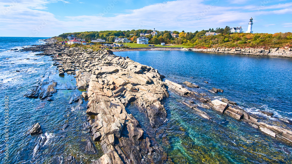 Rocky Maine coastline with shallow waters and lighthouses in background