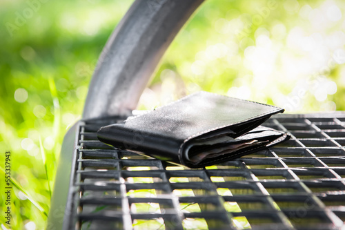 Black wallet on metal bench outdoors. Lost and found photo