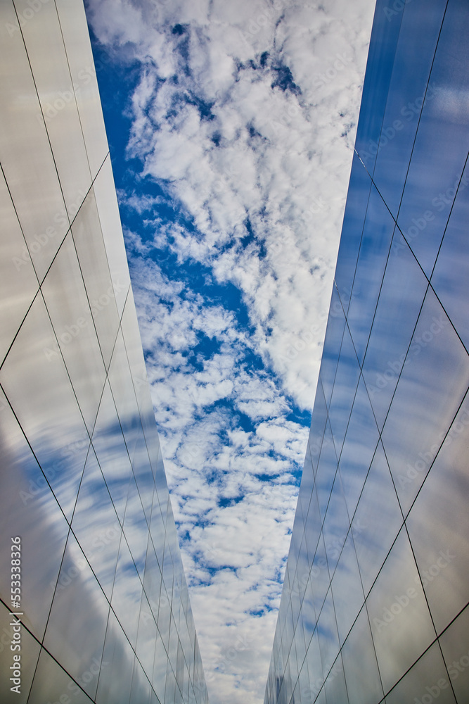 Obraz premium Steel memorial for 9 11 with names of deceased in New Jersey with blue and spotty clouds in sky