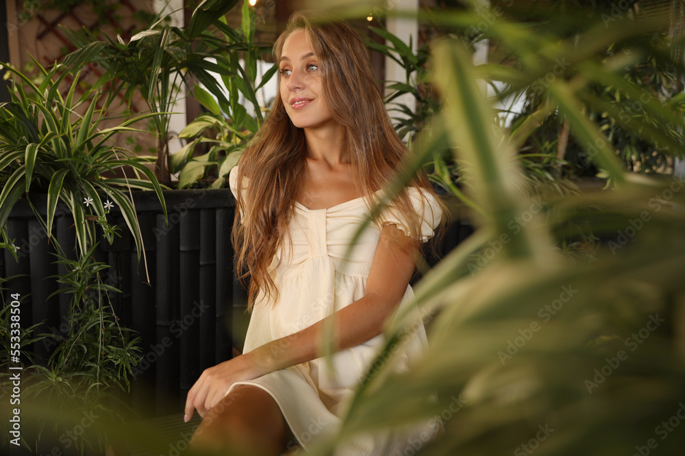 Beautiful young woman sitting on indoor terrace in cafe Beautiful young woman sitting on indoor terrace in cafe