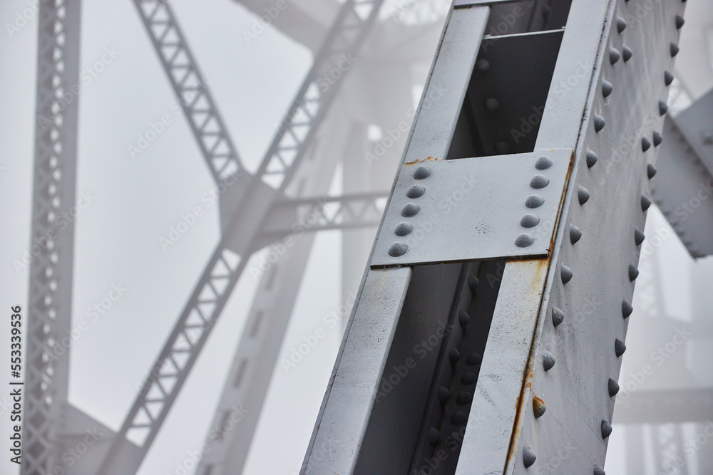 Fototapeta premium Foggy morning detail of steel beams bridge with soft background